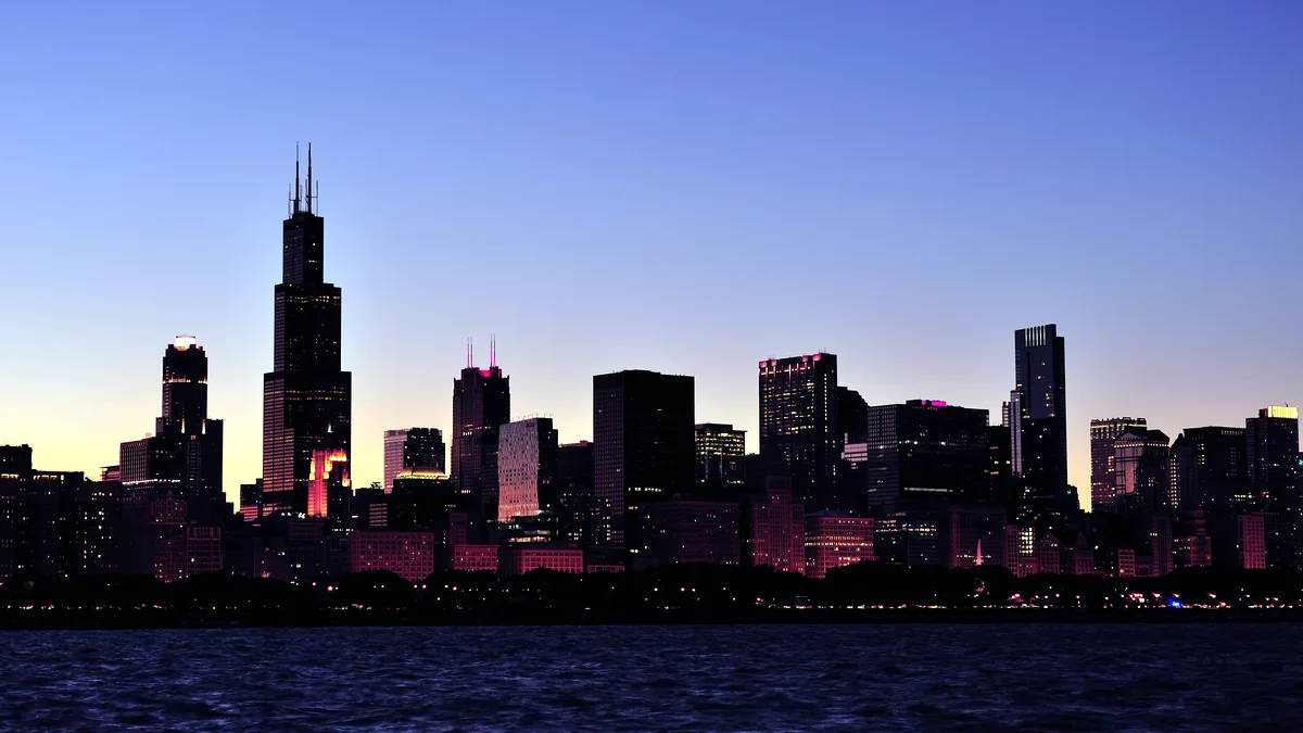The Chicago skyline turning blue at dusk, lights first coming on.