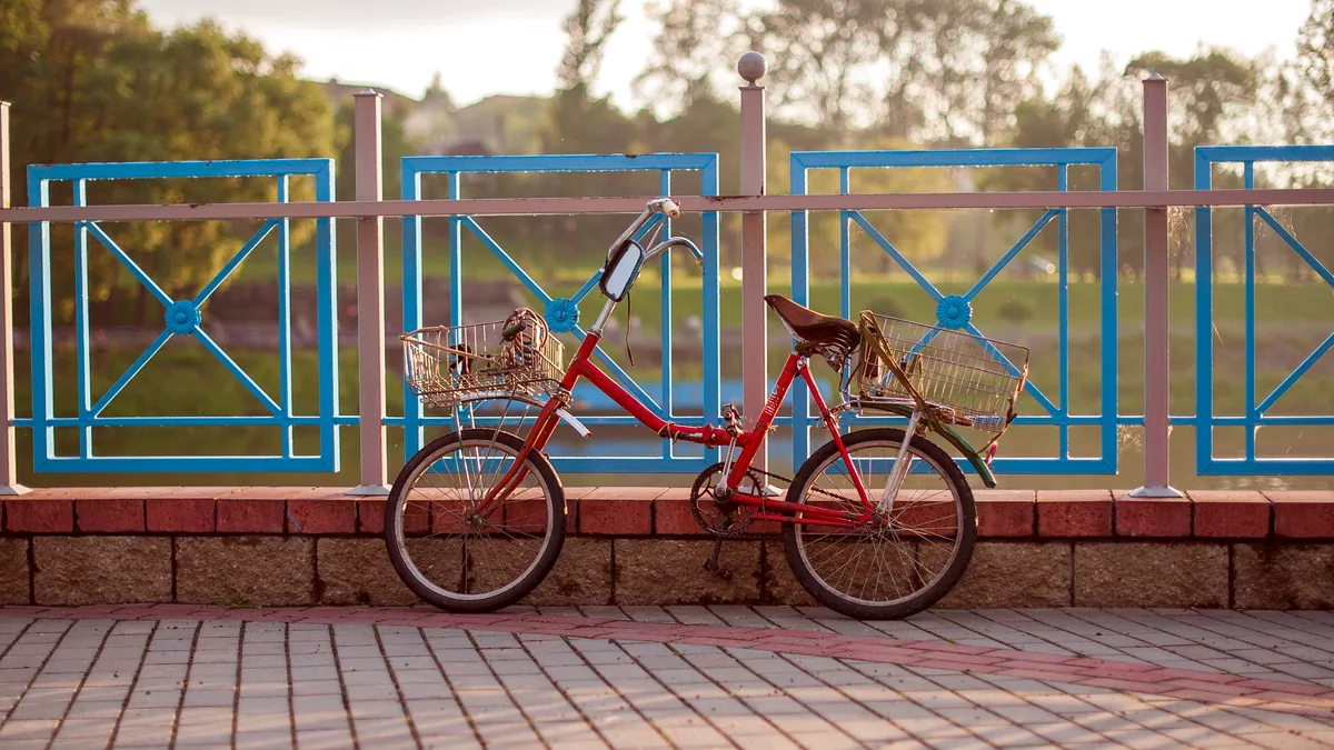 Bicycles leaning against a rail in a sunlit schoolyard at break time.